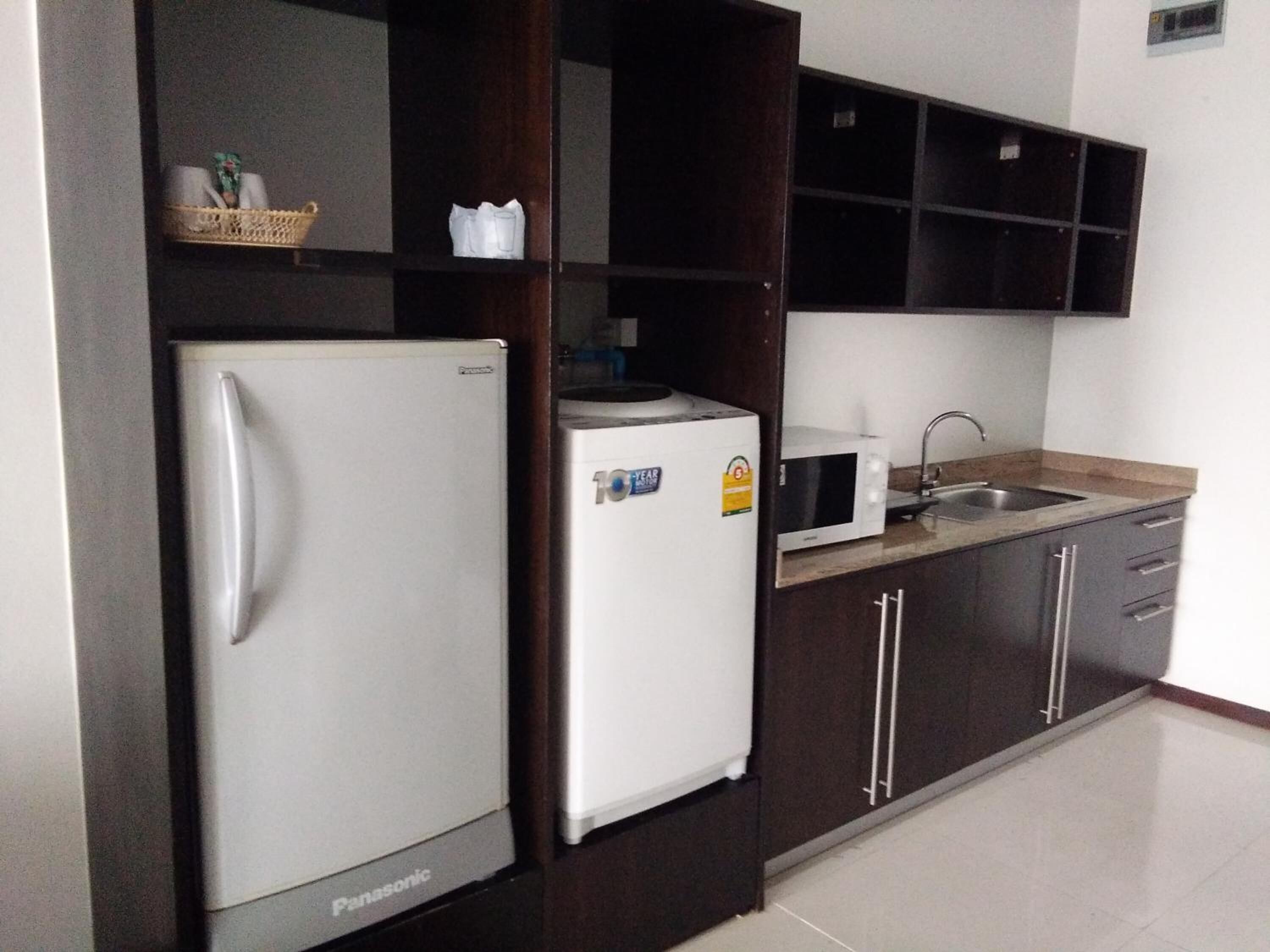 A kitchen with a white refrigerator, a microwave, and a sink.