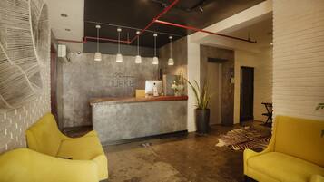 A reception area with a modern design, featuring a concrete reception desk, yellow chairs, and a zebra print rug.