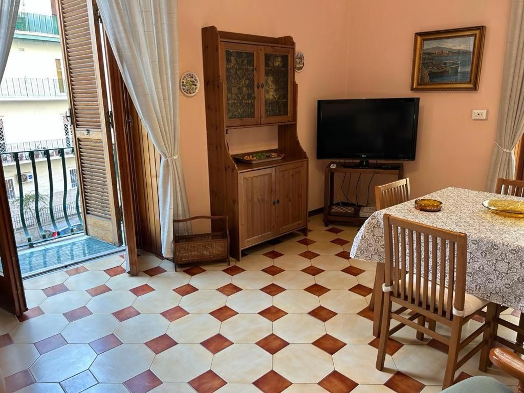 A room with a dining table, chairs, a television, and a cabinet.