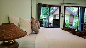 Un dormitorio con cama, almohadas, una lámpara y vistas al exterior.