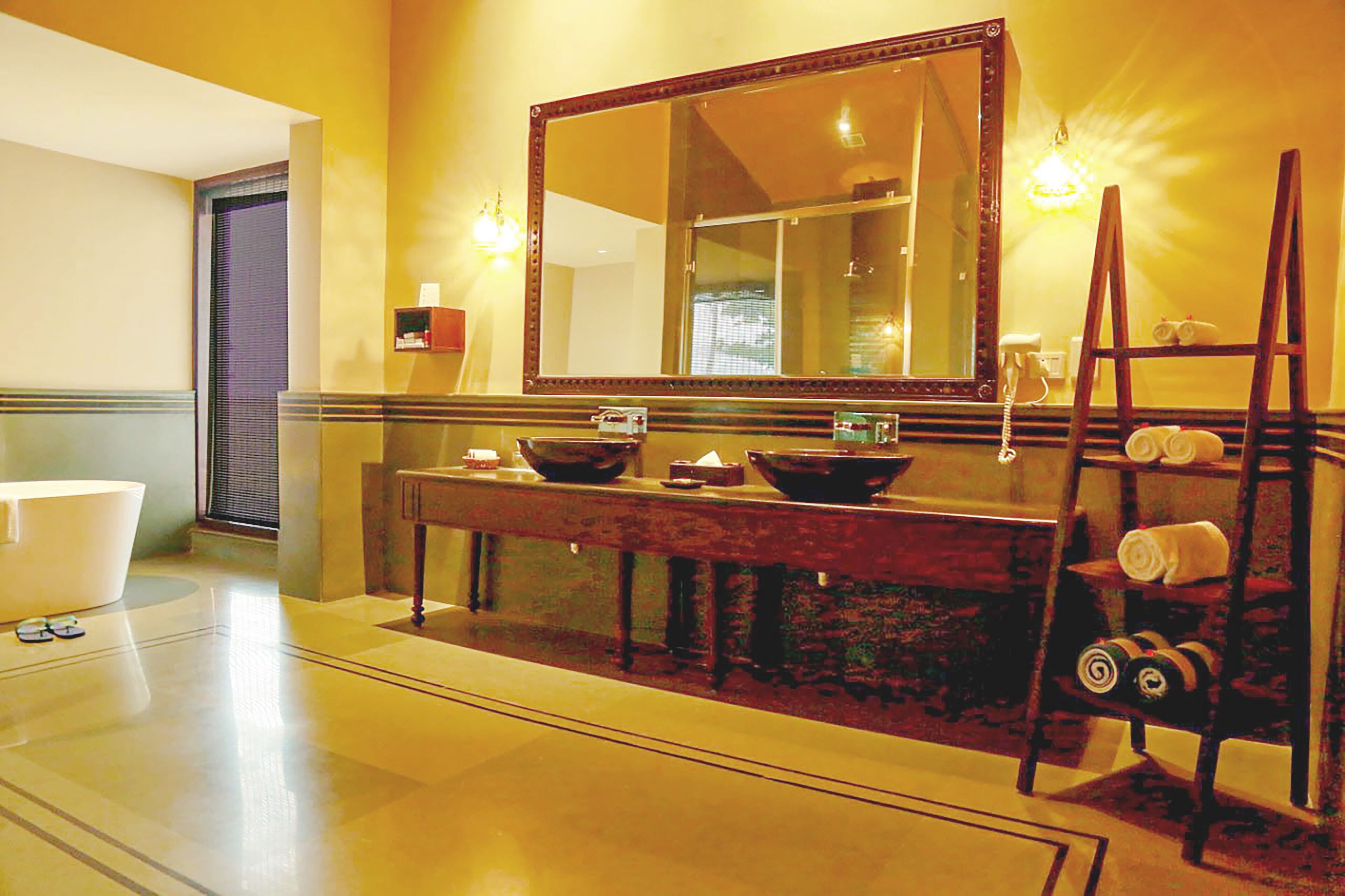 A bathroom with a large mirror, a bathtub, a vanity with a sink, and a towel rack.