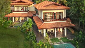 Um resort com várias villas, cada uma com varanda, piscina e exuberantes jardins tropicais.