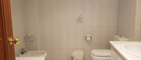 Een badkamer met een bad, toilet en wastafel.