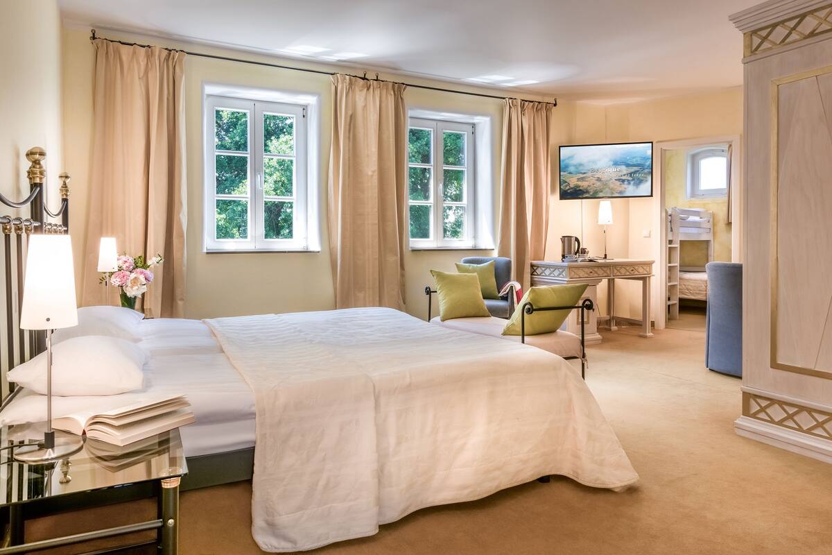 Een hotelkamer met een groot bed, een bureau, een stoel en een televisie.