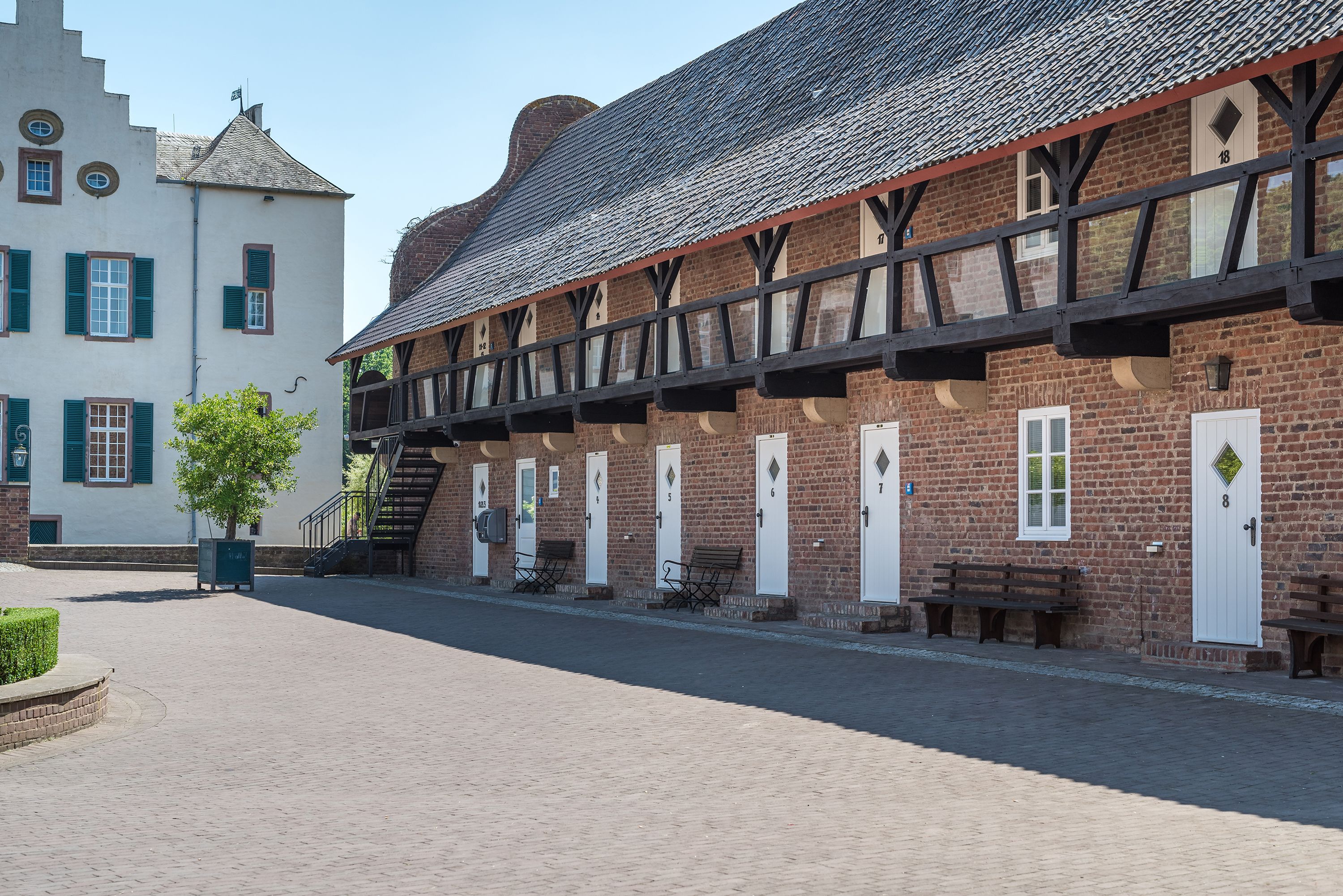 A traditional building with a brick facade, multiple doors, and a covered walkway.