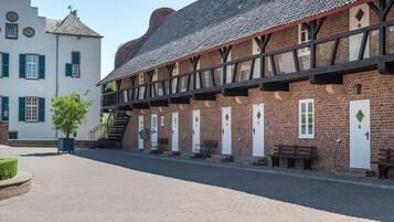 A traditional building with a brick facade, multiple doors, and a covered walkway.
