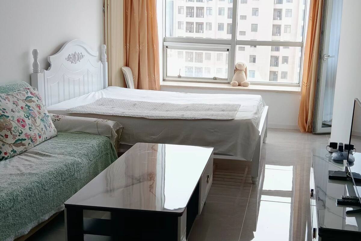 Une chambre à coucher avec un lit, un canapé, une table et un téléviseur.