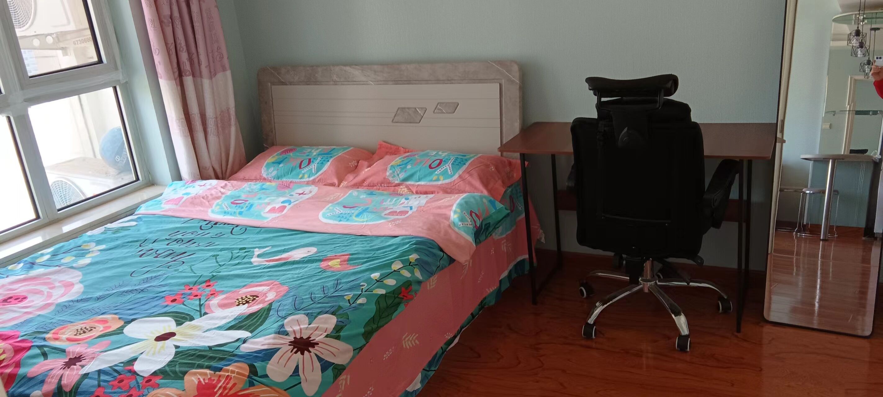Un dormitorio con una cama, un escritorio y una silla.