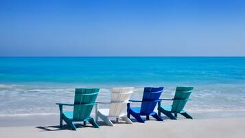 Three beach chairs facing the ocean.