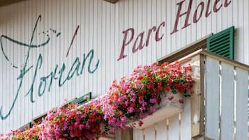 Letrero de hotel con el nombre 'Horan Hotel' y un balcón con flores de colores.