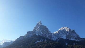 Un paisaje montañoso con picos nevados y un cielo azul despejado.