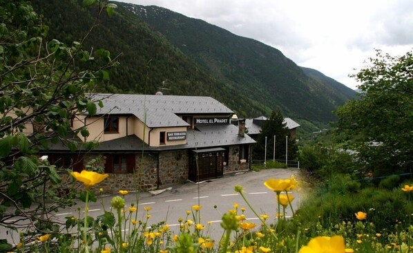 Hotel El Pradet, un hotel con fachada de piedra y un cartel que indica restaurante.