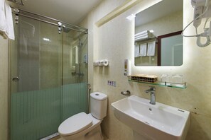 Une salle de bain avec une douche à parois de verre, des toilettes, un lavabo et un miroir.