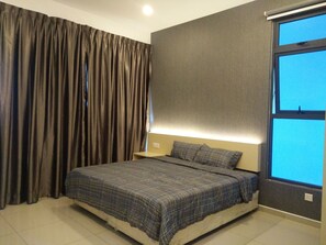 A bedroom with a bed, curtains, a nightstand, and a window. - Atlantics Residence Melaka (Malacca City)
