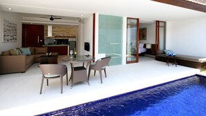 Un espace de vie moderne comprenant un coin repas, un canapé et une piscine.
