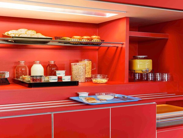 A red buffet setup with various food items and condiments. - hotelF1 Fréjus Roquebrune-sur-Argens (Hôtel rénové) (Roquebrune-sur-Argens)
