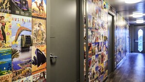 A hallway with travel posters on the walls and a door with a keycard reader.
