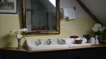 Ein Badezimmer mit Waschbecken, Spiegel und einem gerahmten Bild an der Wand.