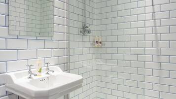 Habitación doble Confort, 1 cama King size | Baño | Regadera, amenidades de baño gratuitas, secadora de cabello, toallas