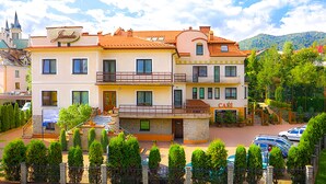 A multi-story hotel with a cafe on the ground floor, a stone facade, and a view of the surrounding area. - JANDA Resort & Conference (Mszana Dolna)