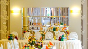 A banquet table with white tablecloths, chairs, and a decorative centerpiece. - JANDA Resort & Conference (Mszana Dolna)