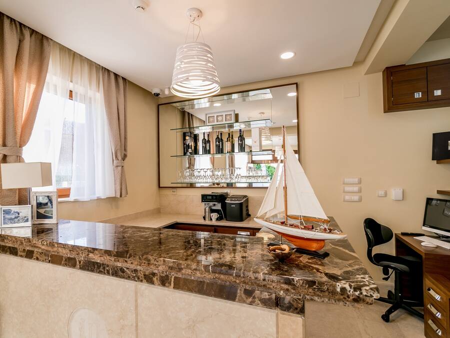 Una cocina moderna con encimera de mármol, un modelo de velero pequeño y una cafetera.