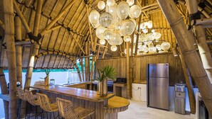 Cocina con motivos de bambú, una isla central, taburetes de bar y un refrigerador.