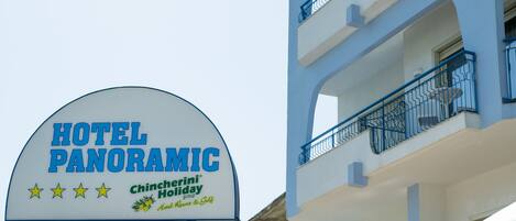 Un letrero de hotel con el nombre "HOTEL PANORAMIC" y el logotipo de "Chincherini Holiday group".
