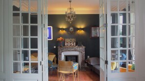 An open room with a fireplace, a chandelier, and a sign that reads "Nice Rose". - Maison Volière (La Souterraine)