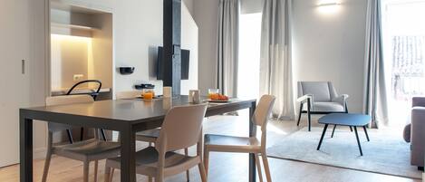 A modern dining area with a table, chairs, and a pendant light.