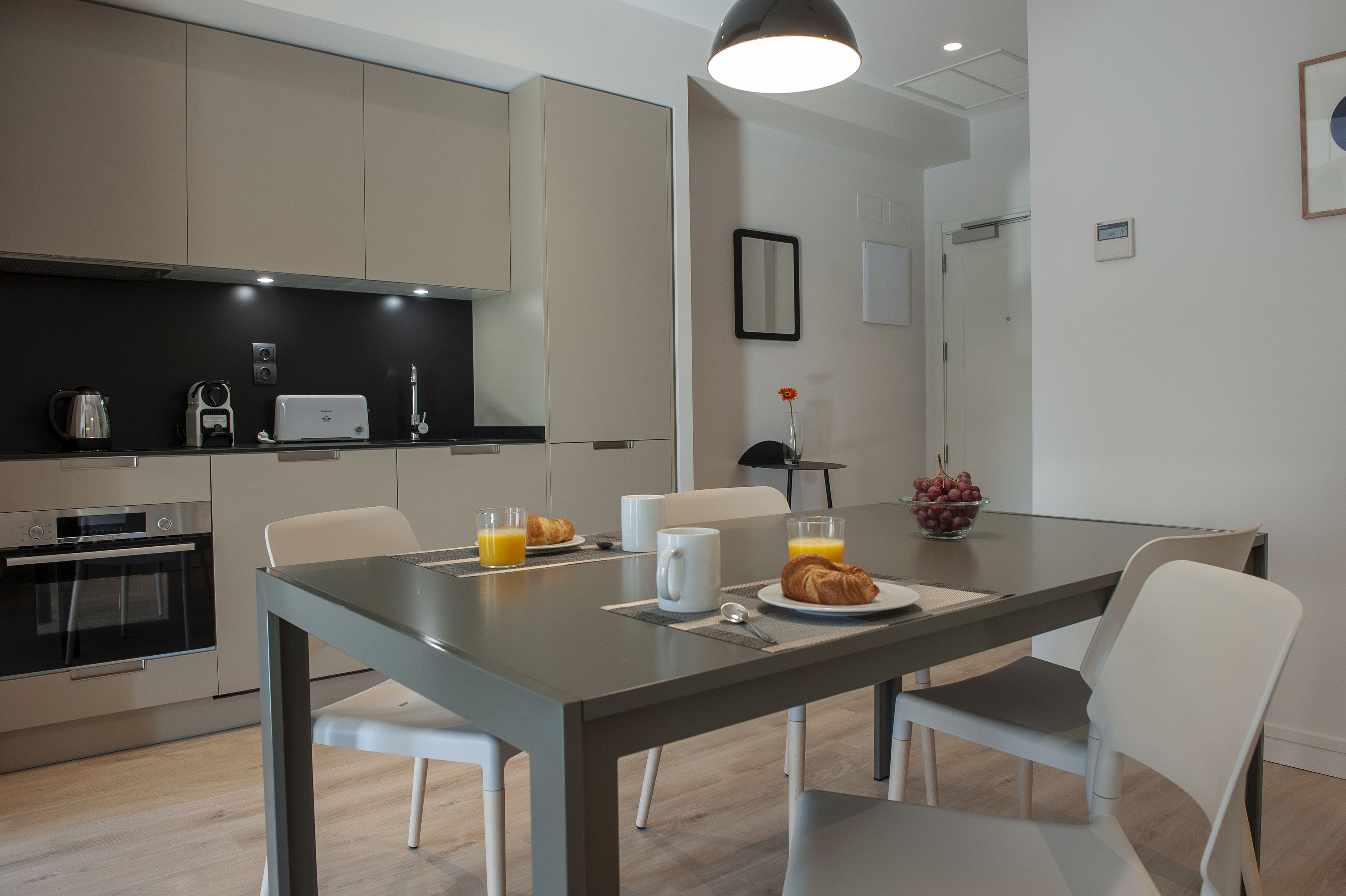 Une cuisine moderne avec une table à manger, des chaises et des aliments pour le petit-déjeuner.