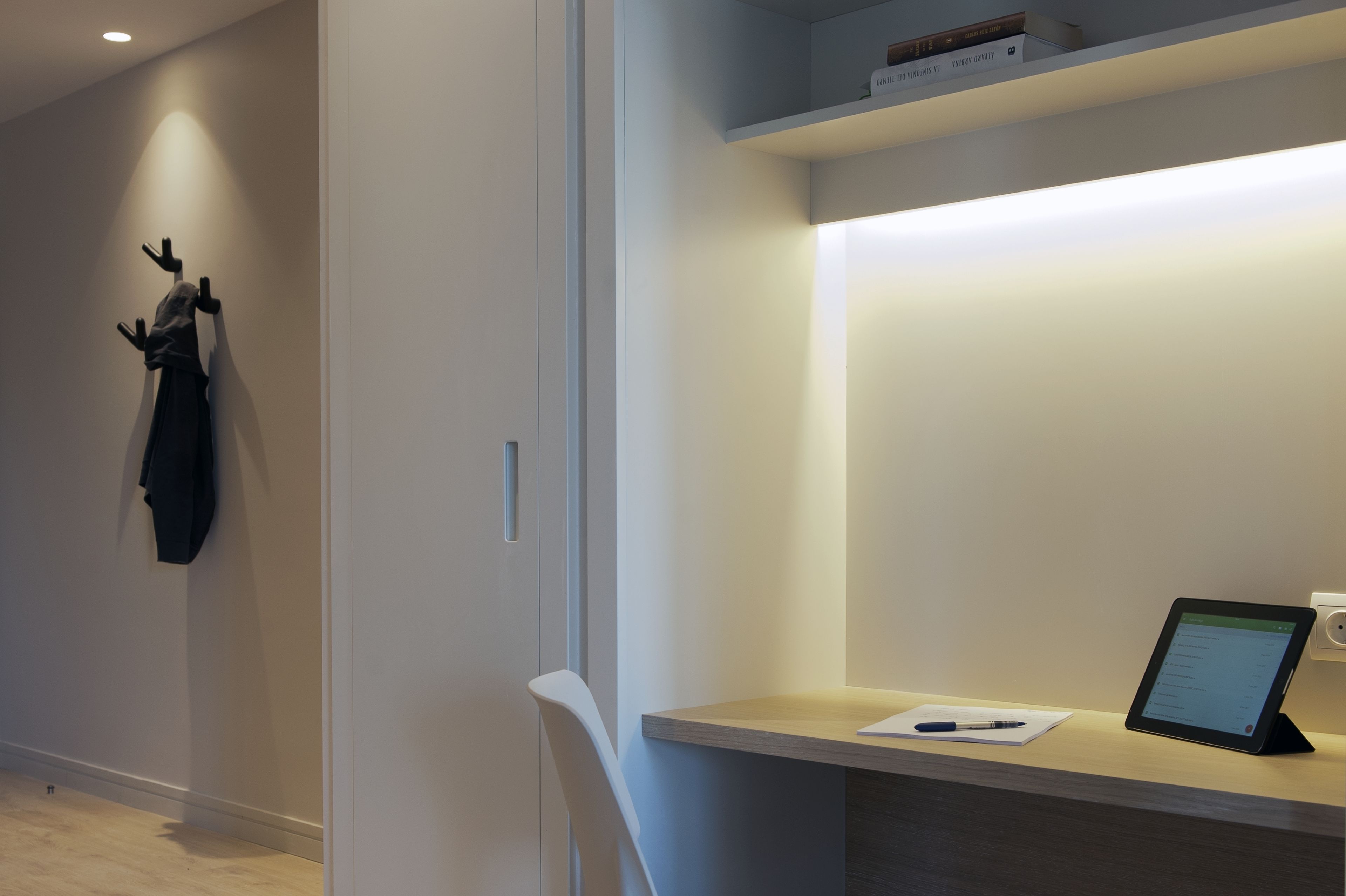 Een moderne kantoorruimte met een bureau, stoel en een tablet.