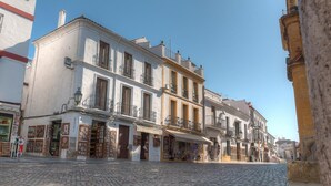 Une rue pavée bordée de bâtiments traditionnels, de boutiques et de balcons.