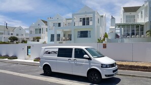 A white van parked on a street with a modern building in the background. - Cape Town Kite Club (Cape Town)