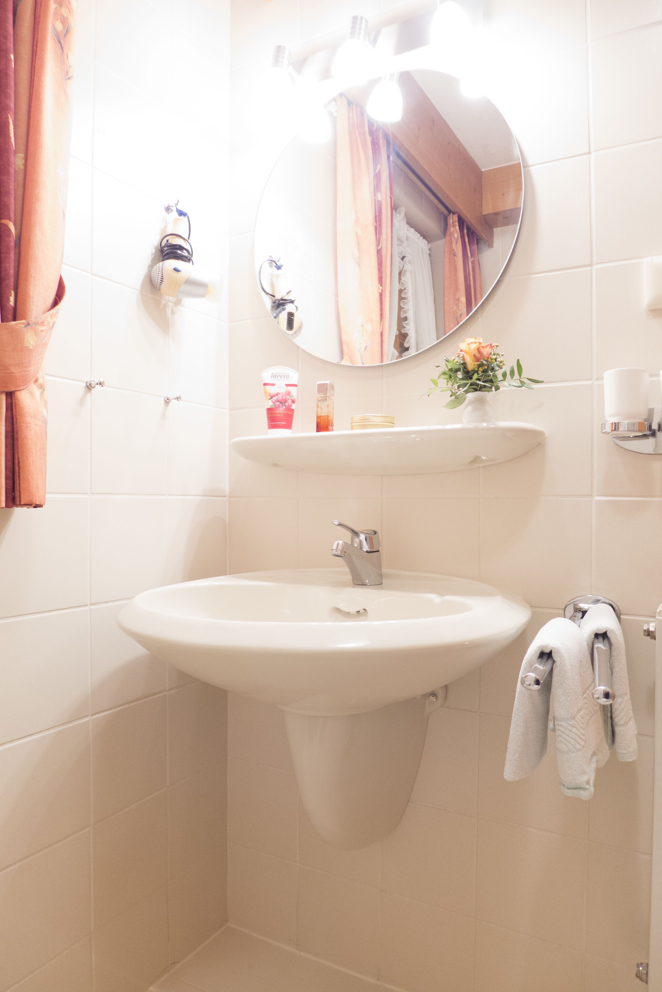 A bathroom with a white sink, a mirror, and a towel rack.