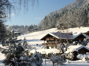 A snow-covered lodge with multiple cabins, surrounded by trees and a snowy landscape. - Landhaus Franziskus (Reit im Winkl)