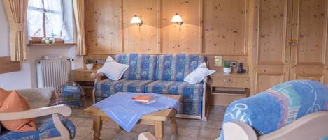 A cozy room with a sofa set, a wooden table, and a cabinet.
