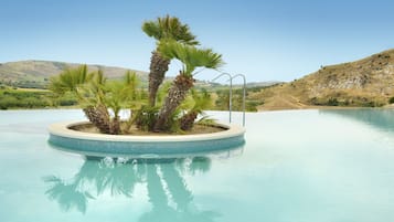 Una piscina al aire libre, sillones reclinables de piscina