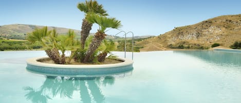 Una piscina al aire libre, tumbonas