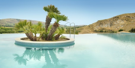 Una piscina al aire libre, sillones reclinables de piscina