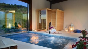 A spa area with a hot tub, wooden cabinets, and candles. - Baglio Caruana Cantina & Relais (Siculiana)