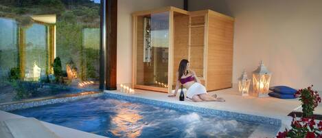 Un espace de bien-être comprenant un jacuzzi, des meubles en bois et des bougies.