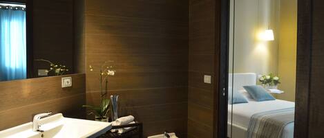 A modern bathroom with a sink, bidet, and mirror.