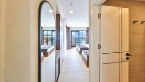 A corridor leading to a bedroom with a balcony, a large mirror, and a wardrobe. - Sardunya Hotel (Kas)