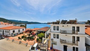 A coastal hotel with multiple floors, outdoor seating, and a view of the sea. - Sardunya Hotel (Kas)