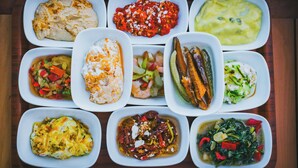 A tray with various dishes including a fish dish, a red sauce with cheese, a green sauce, a shrimp dish, a fish with vegetables, a white sauce, a yellow dish, a red sauce with peppers, and a green leafy dish. - Sardunya Andifli Otel (Kas)