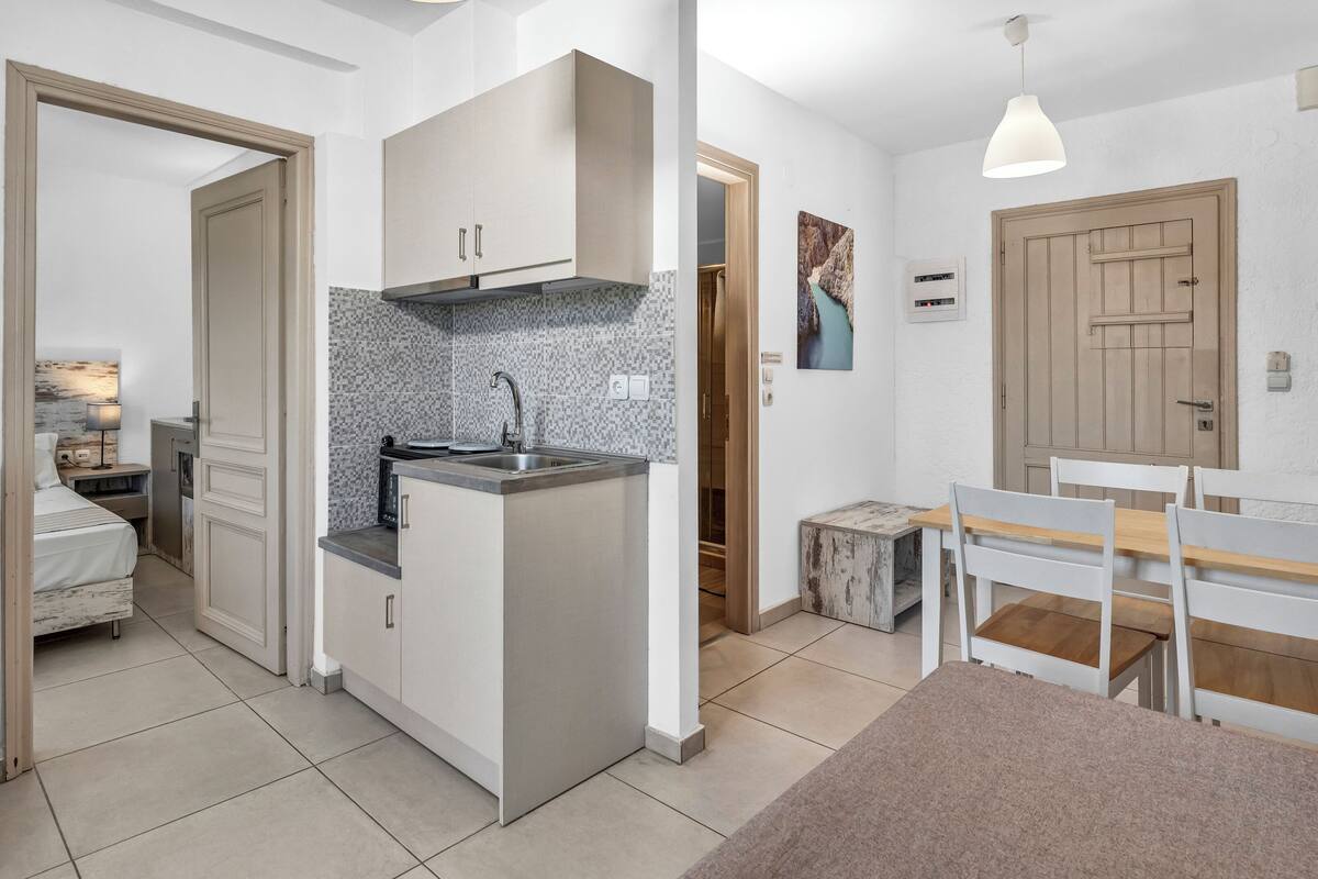 A compact kitchen with a built-in island, a dining area with a bench, and a small seating area.