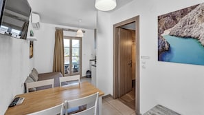 Eine moderne Küche mit einem Holztisch und -stühlen, einem Essbereich mit Blick und einer Tür zum Balkon.