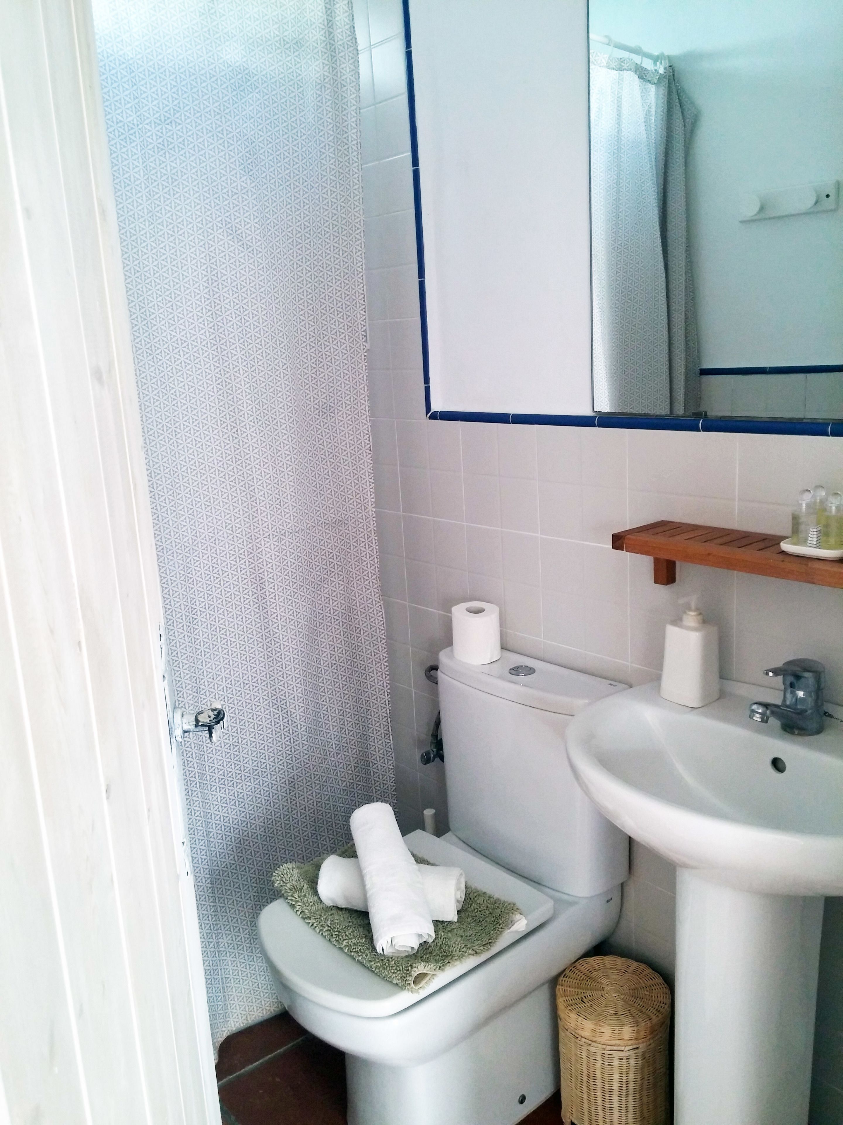 A bathroom with a toilet, sink, and shower.