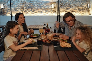 A group of people dining at an outdoor table with various dishes and drinks. - Suite & Breakfast 7 Vizi (Lazise)
